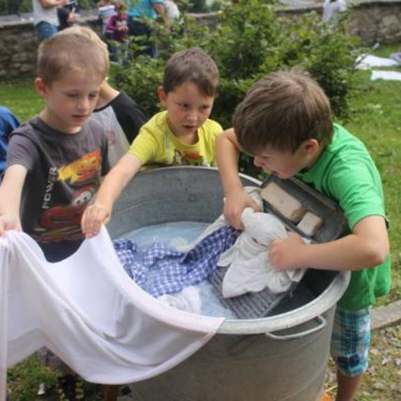 Kinder waschen Wäsche wie vor 100 Jahren